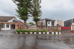 a parking lot in front of a house with a fence at RedDoorz near Taman Kota Lapang Merdeka Sukabumi in Sukabumi