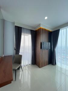 a living room with a chair and a window at Daima Suites Margonda in Perhentian Pondoktjina