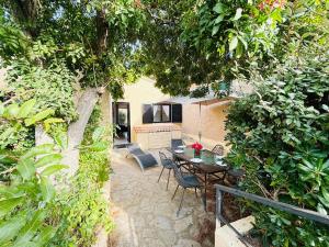 un patio avec une table, des chaises et des arbres dans l'établissement Appartement Solane 4 Lumio, à Lumio