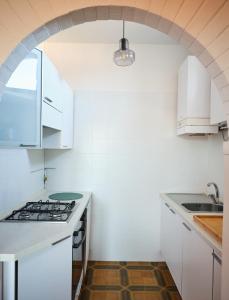 an archway in a white kitchen with a stove top oven at Appartamento Filippo in Baveno