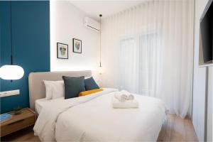 um quarto com uma cama branca e toalhas em Exclusive and Deluxe Apartment in Athens City em Atenas