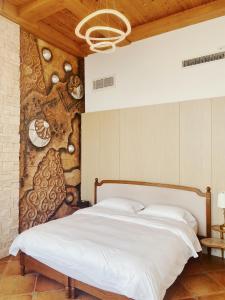 a bedroom with a white bed with a wooden ceiling at Qingdao Villa Inn in Qingdao