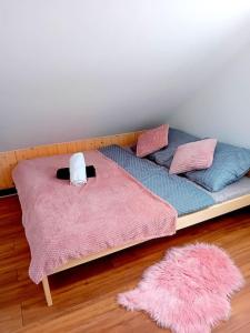 a platform bed with pillows and a pink blanket at Domek u Anitki i Nikosia in Jeleśnia