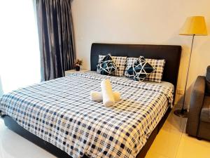 Una cama con un animal de peluche encima. en Summer Suites KLCC By Castle Classy en Kuala Lumpur