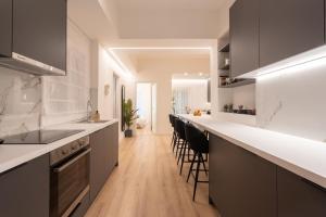uma cozinha com bancadas brancas e armários pretos em Exclusive and Deluxe Apartment in Athens City em Atenas
