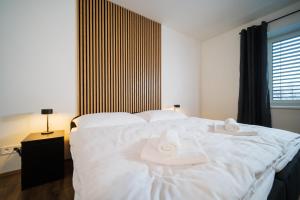 a bedroom with a white bed with towels on it at Rezidence Kolofík in Opava