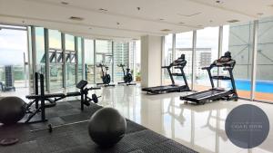 - une salle de sport avec des tapis de course et des équipements d'exercice dans un bâtiment dans l'établissement White Nordic Fully-Furnished Studio at INSPIRIA, à Davao