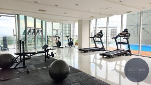 a gym with treadmills and exercise equipment in a building at White Nordic Fully-Furnished Studio at INSPIRIA in Davao City