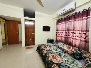 a bedroom with a bed and a curtain with roses at Aaira guest house in Dhaka