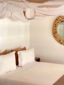 a bedroom with a bed with a mirror on the wall at VOVO TELO LODGE in Toliara