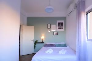 a white bedroom with a bed and a window at דאוס האוס - דירות אירוח מודרניות ושקטות in Eilat