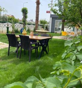 einen Tisch und Stühle im Gras im Hof in der Unterkunft Kelebek Apart Hotel in Fethiye
