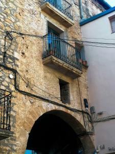 Vila Closa Juncosa في Juncosa: مبنى حجري قديم مع بوابة وشرفة