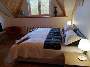 een slaapkamer met een bed en een bureau met een lamp bij Ramus poilsis prie Širvintų marių in Širvintos
