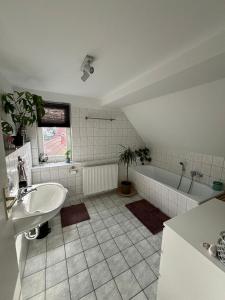 a bathroom with a tub and a sink and a bath tub at Ferienwohnung „Ruppbergblick“ in Zella-Mehlis