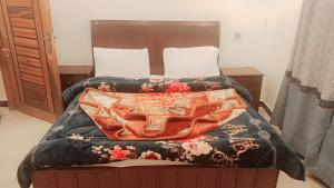 a bed with a blanket on top of it at The Lavish Inn in Murree