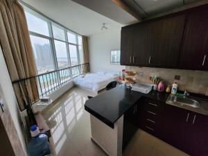 a kitchen with a view of a living room at Comfy Studio with Stunning Vista, Pool and Gym in Abu Dhabi