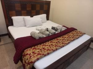 a bed with three dogs laying on top of it at The Lavish Inn in Murree