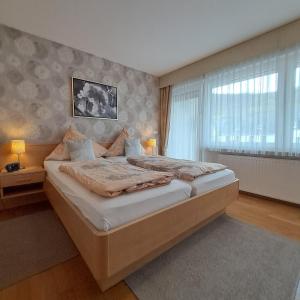 a bedroom with a large bed and a window at Wein- und Gästehaus Lentes in Trittenheim