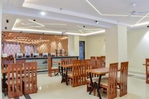 a restaurant with wooden tables and chairs and a counter at HOTEL YASH PALACE in New Delhi