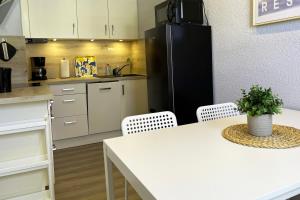 cocina con mesa blanca y nevera negra en Ferienhaus Selbitz, en Selbitz