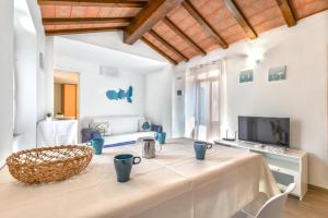 sala de estar con mesa y TV en Casa Arancio en SantʼIlario in Campo