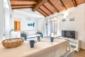 a living room with a table and a tv at Casa Arancio in SantʼIlario in Campo