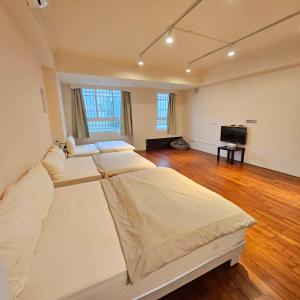 um quarto com 3 camas e uma televisão de ecrã plano em Maybe Homestay em Longjing