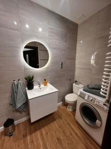 a bathroom with a sink and a washing machine at Apartamenty In Centro by 3 maja in Gniezno