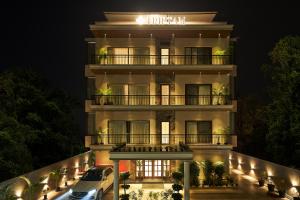 an apartment building at night with a car parked in front at Triptam Vrindavan in Vrindāvan