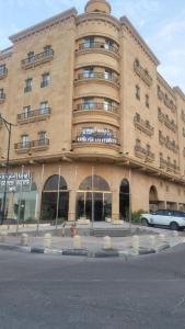 un grand bâtiment avec une voiture garée devant lui dans l'établissement اجنحة أروى سويتس الدمام Arwa Suites Dammam, à Dammam
