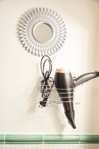 a hair dryer and a mirror on a wall at Benignicase in Rome