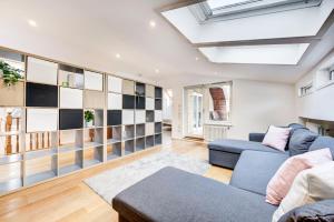 a living room with a blue couch and a skylight at Duplex Apartment Shoreditch - the Living Elite Collection in London