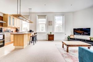 a living room with a table and a kitchen at Duplex Apartment Shoreditch - the Living Elite Collection in London