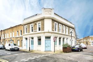 un bâtiment blanc dans une rue avec des voitures garées devant dans l'établissement Duplex Apartment Shoreditch - the Living Elite Collection, à Londres