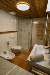 a bathroom with a toilet and a tub and a sink at Chalet 1593 in Vandans