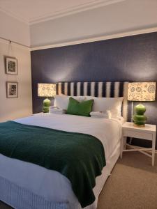 um quarto com uma cama grande e um cobertor verde em Edward Lodge New Fam em Brisbane