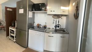 a small kitchen with a sink and a refrigerator at Villa Serendipity Terrasini in Terrasini