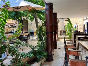 eine Außenterrasse mit Tischen, Stühlen und einem Sonnenschirm in der Unterkunft Villa Citronella Boutique Hotel in Antalya