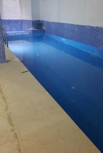 una piscina de agua azul en un edificio en MİDYAT LADİNOS OTEL, en Midyat