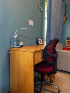 un escritorio con una silla y una lámpara. en Aqua Inn - Studio Apartment, en Greater Noida