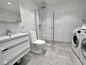 a bathroom with a toilet and a washing machine at Elegant Apartment In The Heart Of The City in Gothenburg