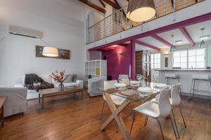 Un comedor y una sala de estar con mesa y sillas. en Únika Homes Porvenir, en Sevilla