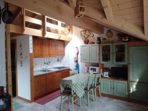 una cucina con armadi in legno e tavolo con sedie di "Fresia" Cottage Turistico a Fisto a Spiazzo