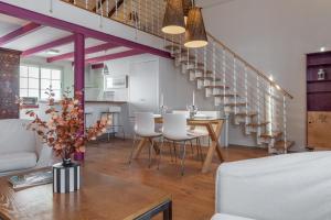 Un comedor con una mesa y sillas blancas. en Únika Homes Porvenir, en Sevilla