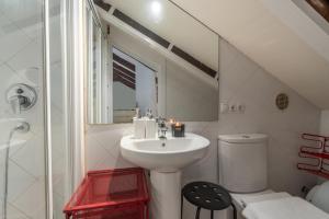 Un baño blanco con lavabo e inodoro. en Únika Homes Porvenir, en Sevilla