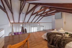 Habitación con cama y TV en la pared. en Únika Homes Porvenir, en Sevilla
