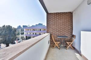 拿坡里的住宿－Sebeto Apartments with Parking & Netflix，砖墙阳台配有桌椅