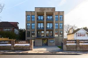 a large brick building with a sign in front of it at The Wembley Park Corner - Classy 2BDR Flat with Balcony in London