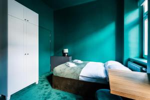 een slaapkamer met groene muren en een bed met een tafel bij Green Gertrudy in Krakau